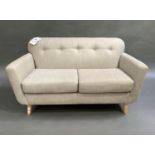 A modern two seater sofa upholstered in buttoned grey fabric, on turned beech legs, 154cm wide