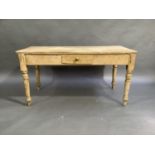 A Victorian stripped pine kitchen table, the frieze fitted with single small drawer on turned