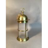 An Edwardian brass cylindrical lantern with domed top and suspension ring, railed frame enclosing