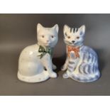 Two Rye pottery cats, one with pale blue markings with red bow, the other decorated with pink