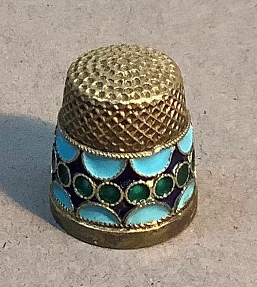 A Russian silver and enamel thimble, band of green enamel circles on a dark blue ground with