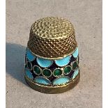 A Russian silver and enamel thimble, band of green enamel circles on a dark blue ground with