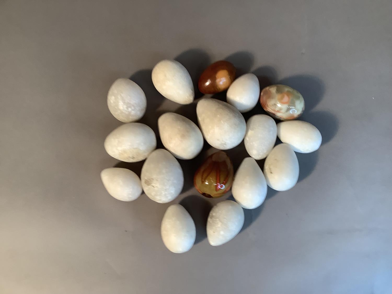 A collection of fourteen white alabaster eggs, various sizes, approximate 6cm to 9cm, together