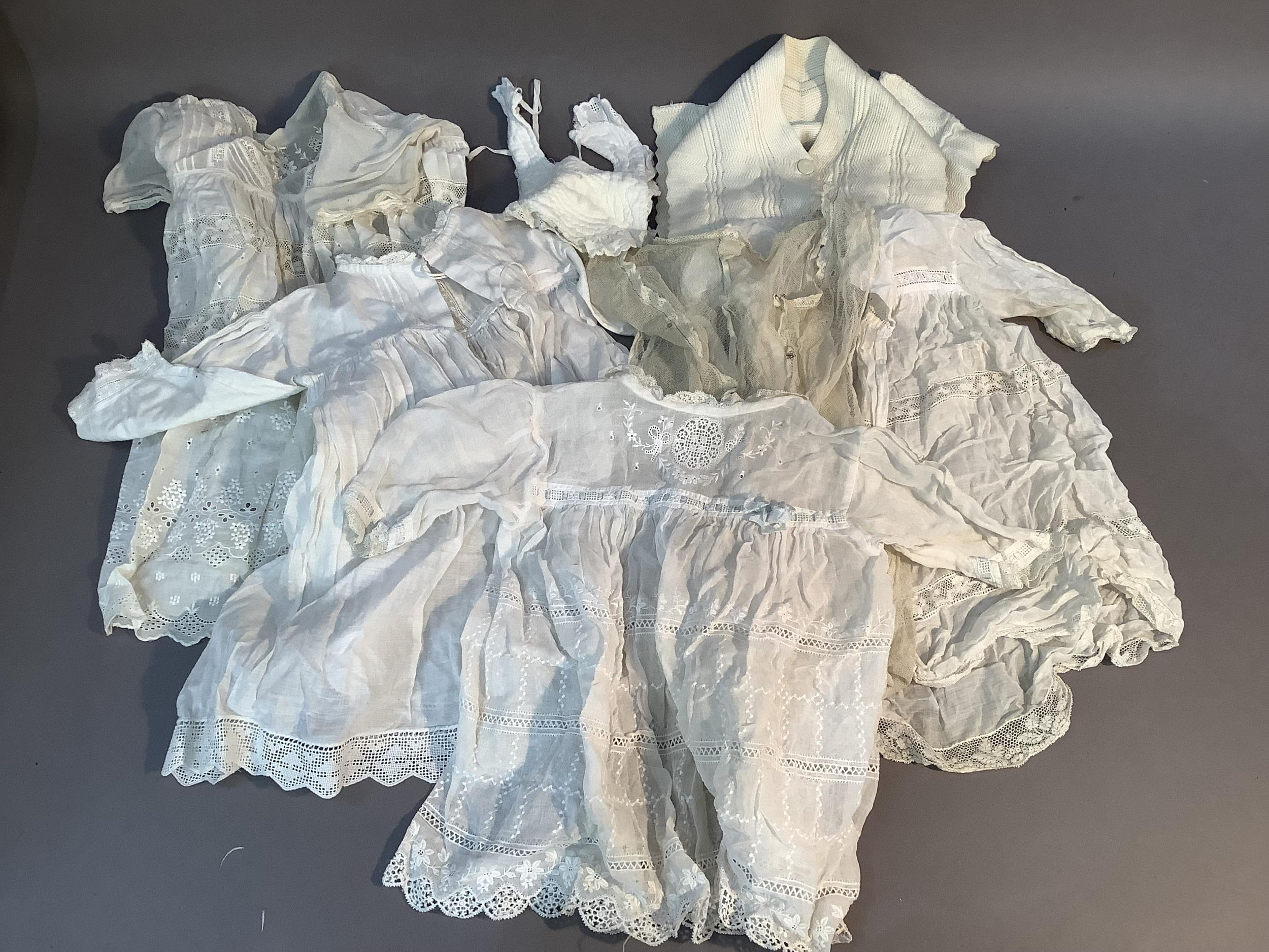 Four Edwardian baby's dresses in fine cotton with embroidered, lace and drawn thread work, a bib,