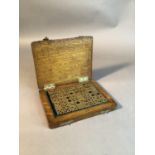 An interesting set of solid brass dominoes contained within a green plush lined oak box, each domino