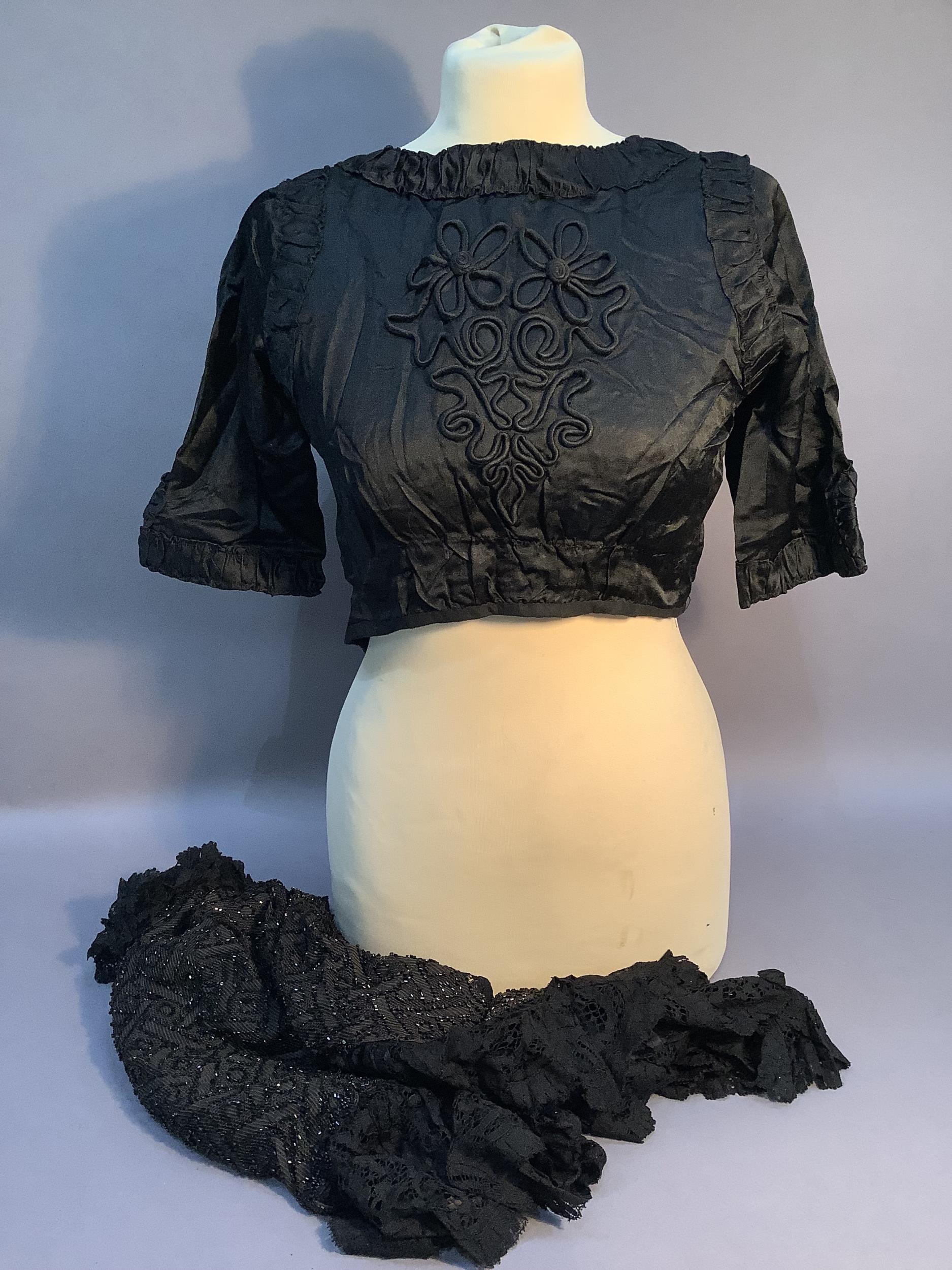 A Victorian dark brown and beaded cape with black lace trim together with a black ruched dress