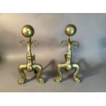 A pair of Victorian brass andirons with sphere and scroll uprights on pair of bold cabriole legs