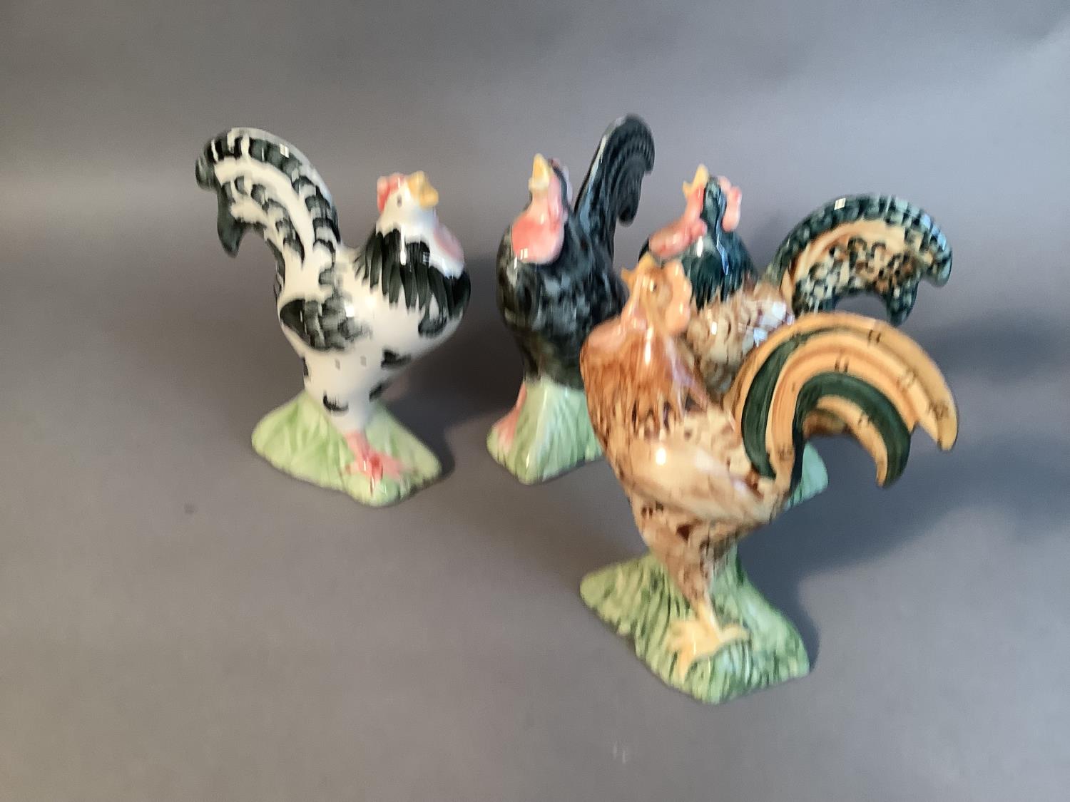 A set of four Alexander pomanders, slip moulded as crowing cockerels, variously decorated, 18cm high