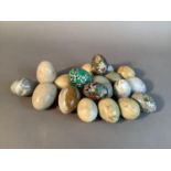 A small collection of alabaster, marble, onyx, enamelled and papier maché eggs