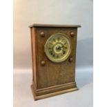 An oak cased mantel clock, early 20th century, the gilt metal dial with black Roman numerals with