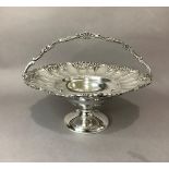 A continental white metal fruit basket of circular outline, fluted and floral embossed rim with cast