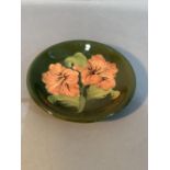 A Moorcroft pottery dished plate, Hibiscus pattern, tube lined and painted in coral and shades of