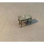 An Edwardian silver miniature table embossed with cherubs within c-scroll cartouche, Birmingham