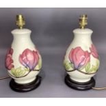 A pair of Moorcroft Magnolia table lamps, tube lined and painted in mauve, pink, green and brown