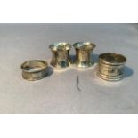 A pair of silver napkin rings, another engraved and a fourth of engine turned decoration, three with