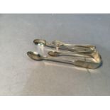 A pair of silver sugar tongs, London 1855, maker's mark indistinct together with a smaller pair,