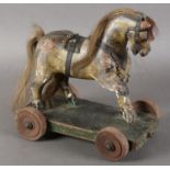 A 19TH CENTURY PULL-A-LONG HORSE, carved wood with gesso finish, real hair mane and tail, leather