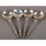 A SET OF FOUR EDWARD VII SILVER SPOONS with circular bowls, ornate engraved stems with central