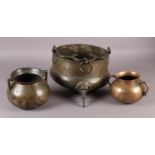 A LATE 17TH CENTURY BRONZE SPHERICAL BELLIED TWO HANDLED CAULDRON with spreading lip, plain scroll