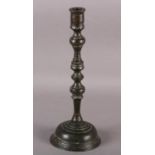 A LATE 17TH CENTURY BRONZE CANDLESTICK of knopped form with spreading circular base, 31cm high
