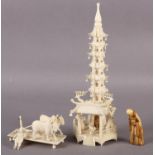 AN IVORY TEMPLE TOWER set on a hexagonal base fitted with figures, pagoda and trees, 24cm high; a