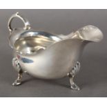 A VICTORIAN SILVER SAUCE BOAT IN GEORGE III STYLE with shaped rim and acanthus capped flying