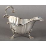 A GEORGE V SILVER SAUCE BOAT IN GEORGE II STYLE with applied reeded rim and double C-scroll flying