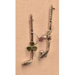 Two silver golf bar broaches, both having golf club with one having longnose with ball and purple