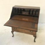 MAHOGANY BUREAU with a fall flap opening to reveal a fitted interior, above two short and two long