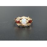 OPAL AND GARNET RING the central oval cabochon opal flanked by oval cut garnets, in pierced and