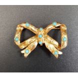 TURQUOISE SET BOW SHAPED GOLD BROOCH in unmarked high carat gold, approximately 3.3cm wide and 4.5
