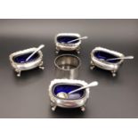 TWO PAIRS OF SILVER SALTS all raised on four pad feet and with blue glass liners, one pair
