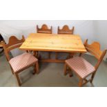 WAXED PINE KITCHEN TABLE with an oblong top standing on shaped carved end supports united by a