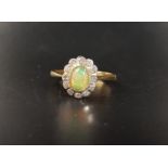 OPAL AND DIAMOND CLUSTER RING the central oval cabochon opal in twelve diamond surround, on eighteen
