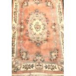 RECTANGULAR CHINESE WASH RUG with a pale pink ground with floral motifs, encased by a cream floral