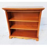 YEW BOOKCASE with a moulded dentil cornice above adjustable shelves, standing on bracket feet,