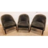 THREE SLATE GREY VELVET COVERED CHAIRS with shaped arched backs above padded seats, standing on