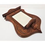 EDWARDIAN OAK FRAME SHIELD SHAPE HALL MIRROR with carved decoration around a square beveled plate
