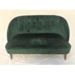 MODERN DARK GREEN VELVET SOFA with a shaped button back above a stuffover seat, standing on turned