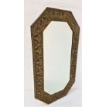 ARTS AND CRAFTS WALL MIRROR with an embossed brass frame around a bevelled plate, 74cm high