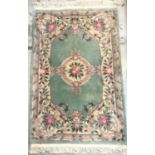 CHINESE WASH RUG the pale green ground with floral motifs, fringed, 192cm x 122cm excluding fringe