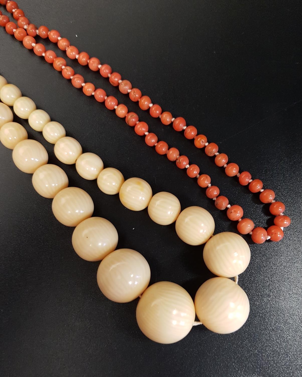 GRADUATED IVORY BEAD NECKLACE 49cmlong; together with a coral bead necklace, 55cm long (2)