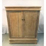 LIMED OAK SIDE CABINET with a moulded top above a pair of panelled cupboard doors opening to