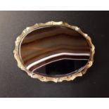 LARGE OVAL BANDED AGATE BROOCH in unmarked gold scroll decorated mount, 6cm wide