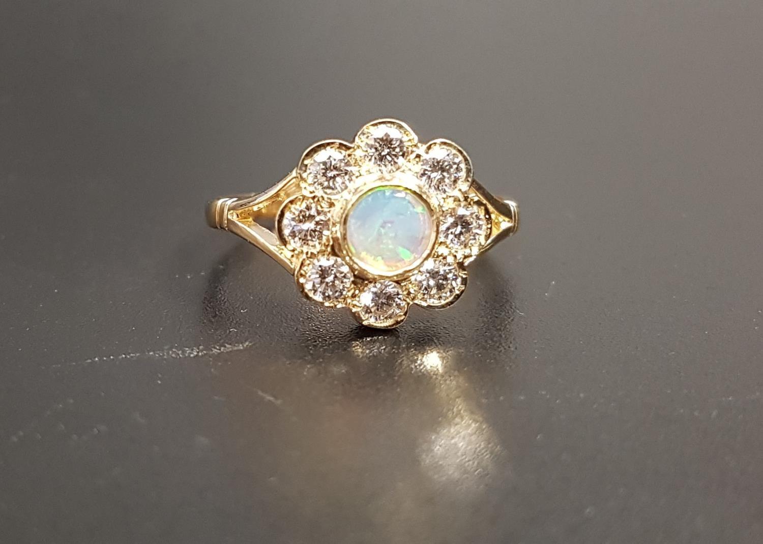 PRETTY OPAL AND DIAMOND CLUSTER RING the central round opal in eight diamond surround totaling