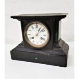 VICTORIAN BLACK SLATE MANTLE CLOCK in a shaped case with a circular white enamel dial with an