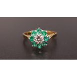 EMERALD AND DIAMOND CLUSTER RING the central round brilliant cut diamond approximately 0.25cts in