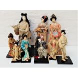 NINE JAPANESE FIGURE ORNAMENTS all in traditional dress, including Geisha and a Samurai warrior, all