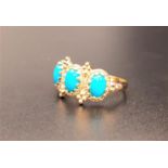 TURQUOISE THREE STONE RING in decorative moulded setting, on nine carat gold shank, ring size N