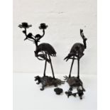 PAIR OF JAPANESE BRONZE CANDLE HOLDERS depicting herons riding mythical beasts, each with a two